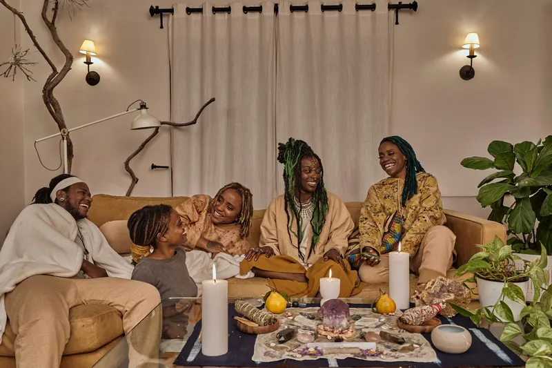 Friends sharing a meal in a candle-lit living room